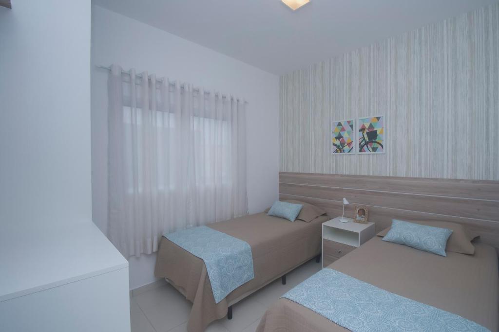เตียงในห้องที่ Residencial Anchieta Riviera By Audaar