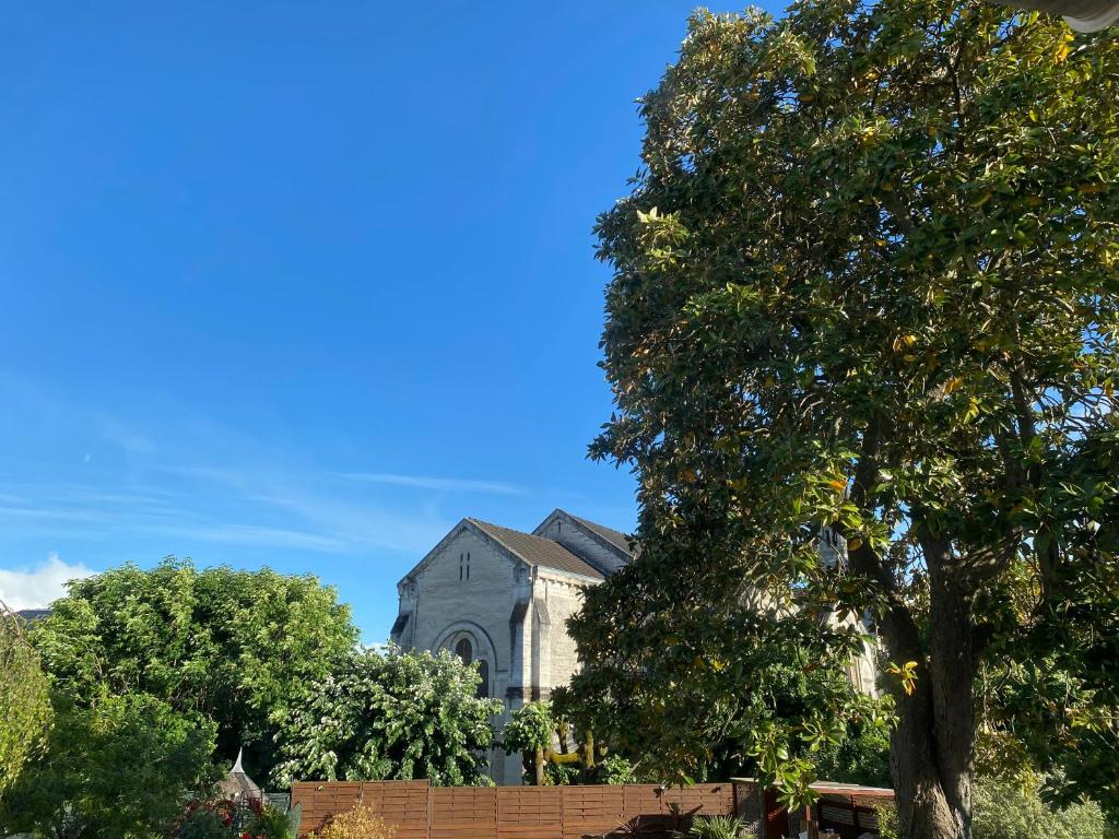 a church with a tree in front of it at Le Clos Saint Martin in Périgueux