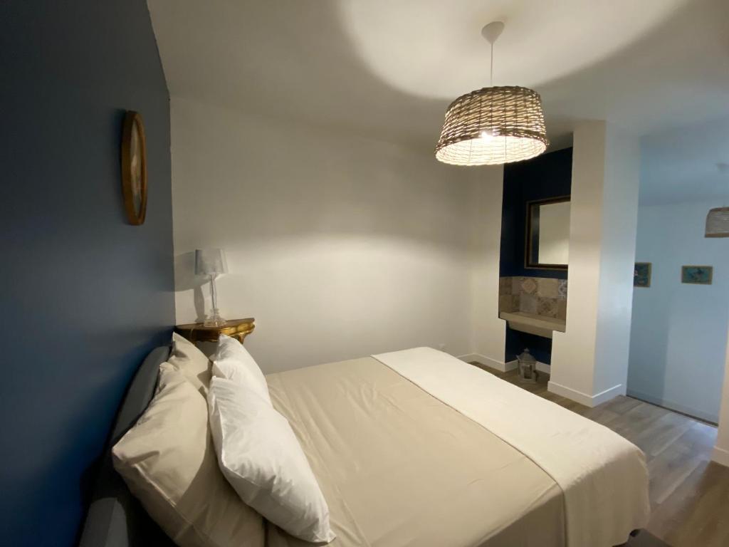 a bedroom with a white bed and a pendant light at Le Clos Saint Martin in Périgueux