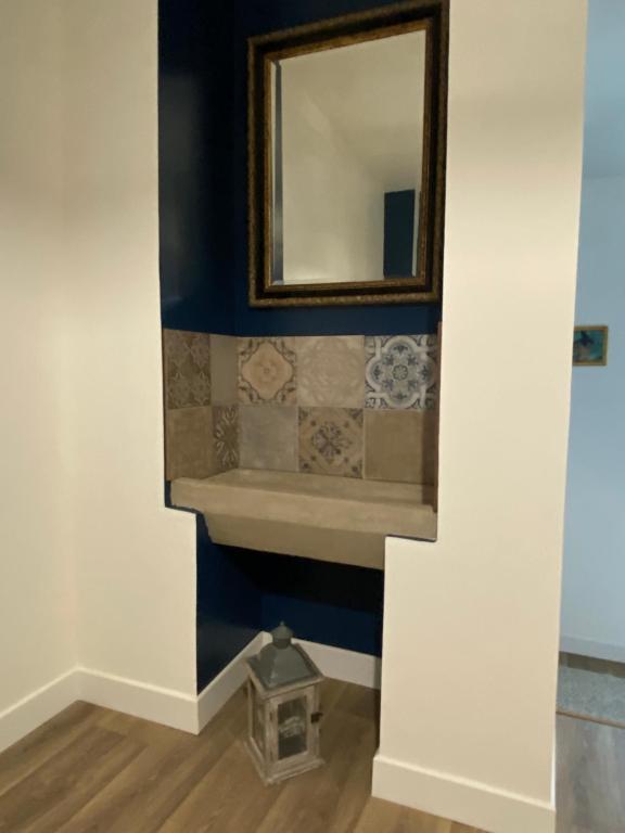 a mirror on a wall with a sink in a room at Le Clos Saint Martin in Périgueux