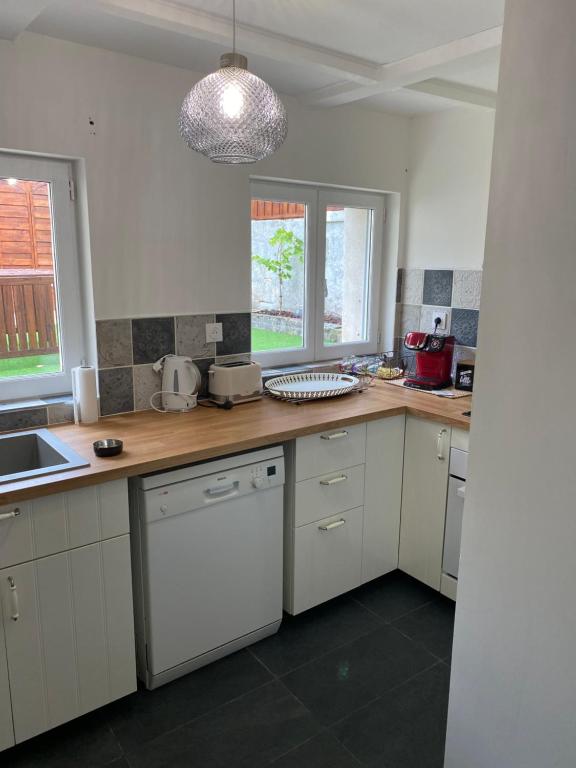 a kitchen with white cabinets and a wooden counter top at Le Clos Saint Martin in Périgueux