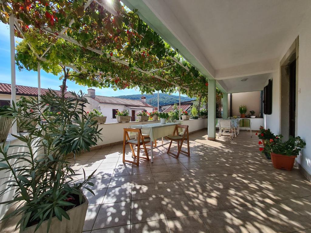 a patio with a table and chairs and plants at Apartment Rabac 2127 in Rabac