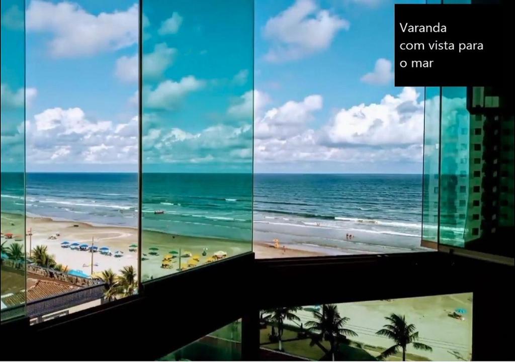 a room with a view of the beach and the ocean at Mongaguá - Pé na Areia - 2 Quartos - 6 pessoas in Mongaguá