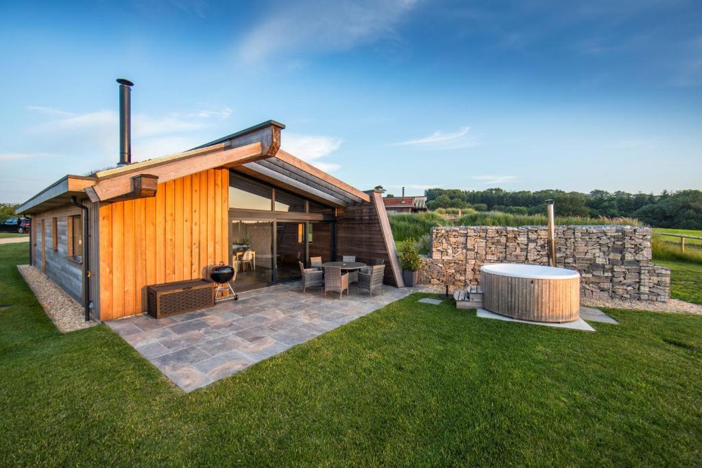 a house with a patio and a stone wall at Bramble in Ansty