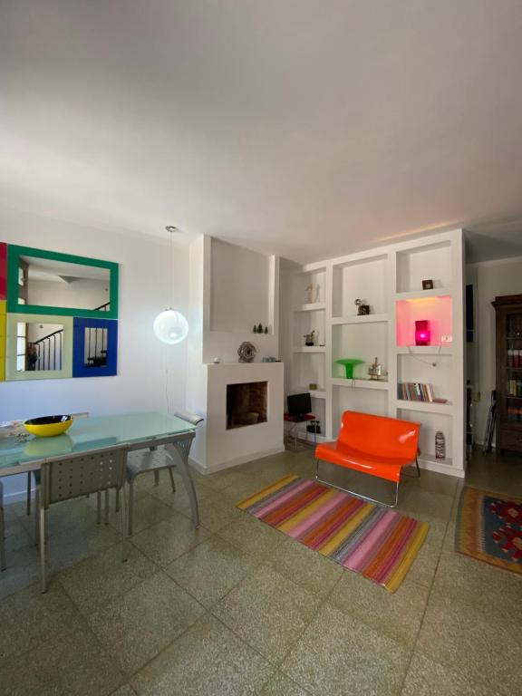 ein Wohnzimmer mit einem Tisch und einem roten Stuhl in der Unterkunft La casetta in Rocca San Felice