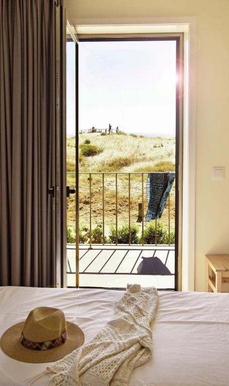 a bedroom with a bed with a view of the beach at Surfivor Surf Camp in Esmoriz