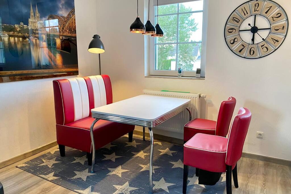 a dining room with a table and two chairs and a clock at Das Nest, wo der Name Programm ist in Dahlem