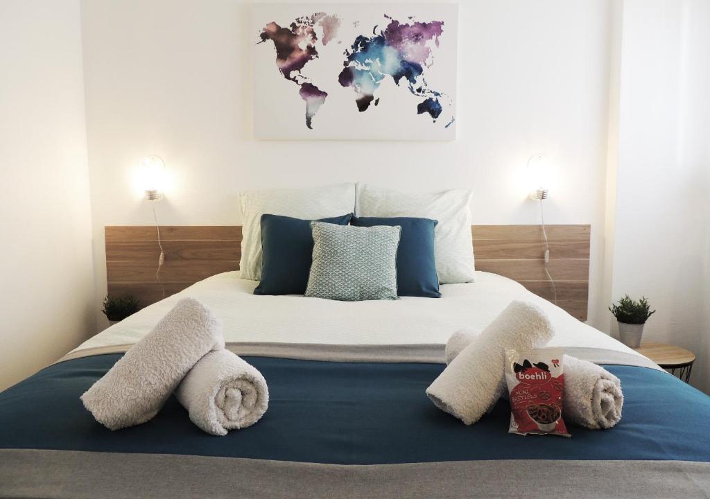 una camera da letto con un grande letto con asciugamani di Appart'AZUR Haguenau - Proche Gare au calme - Wifi - Lit confort - Parking facile et gratuit a Haguenau