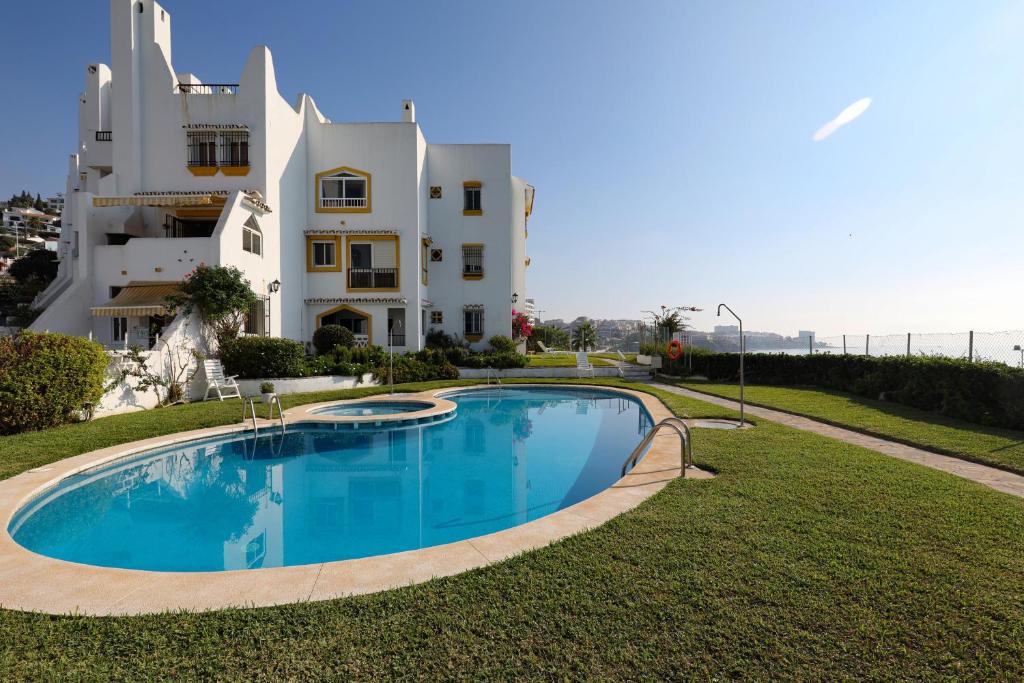 Villa con piscina frente a un edificio en 082 - Stunning Sea Views Beachfront Apartment, en Benalmádena