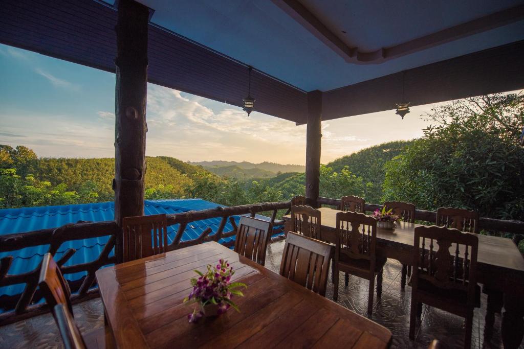 een tafel en stoelen op een veranda met uitzicht bij Mountain View House in Sangkhla Buri