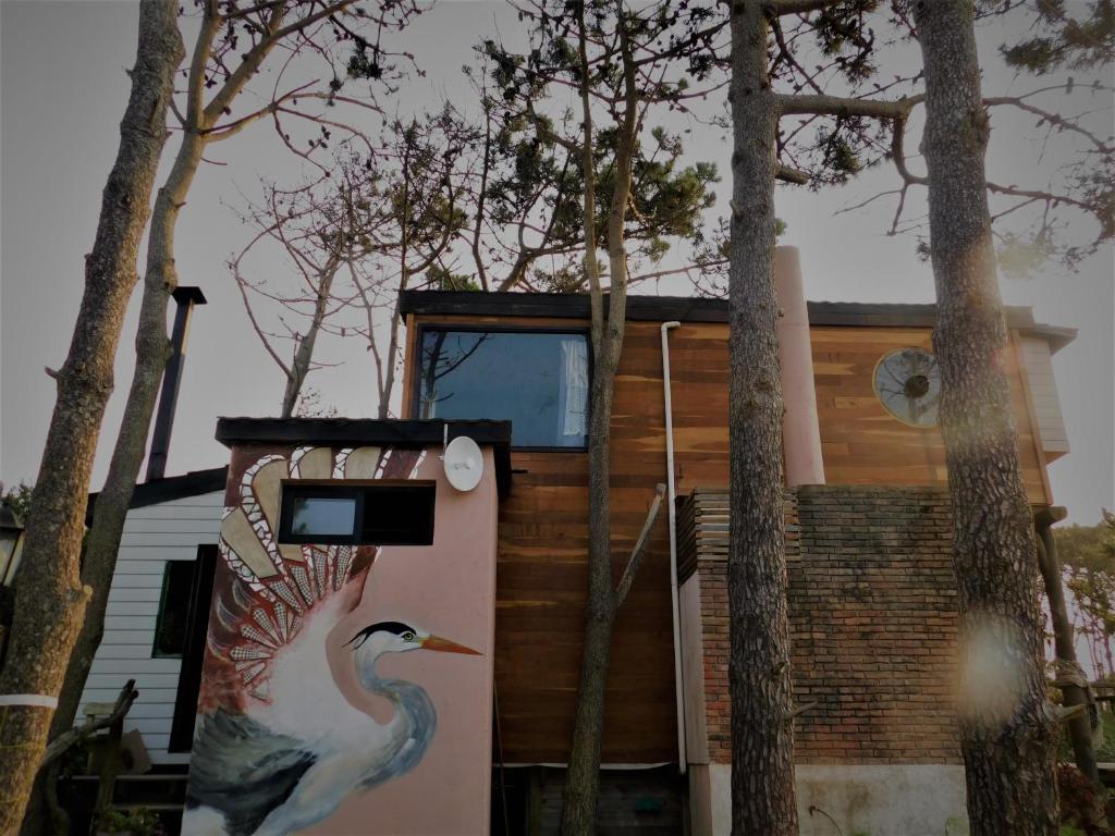 Una casa con un pájaro pintado a un lado. en agata, en Punta del Diablo