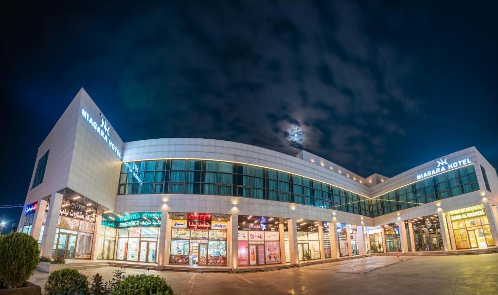 a large building with a lot of windows at night at Niagara Hotel Erbil in Erbil