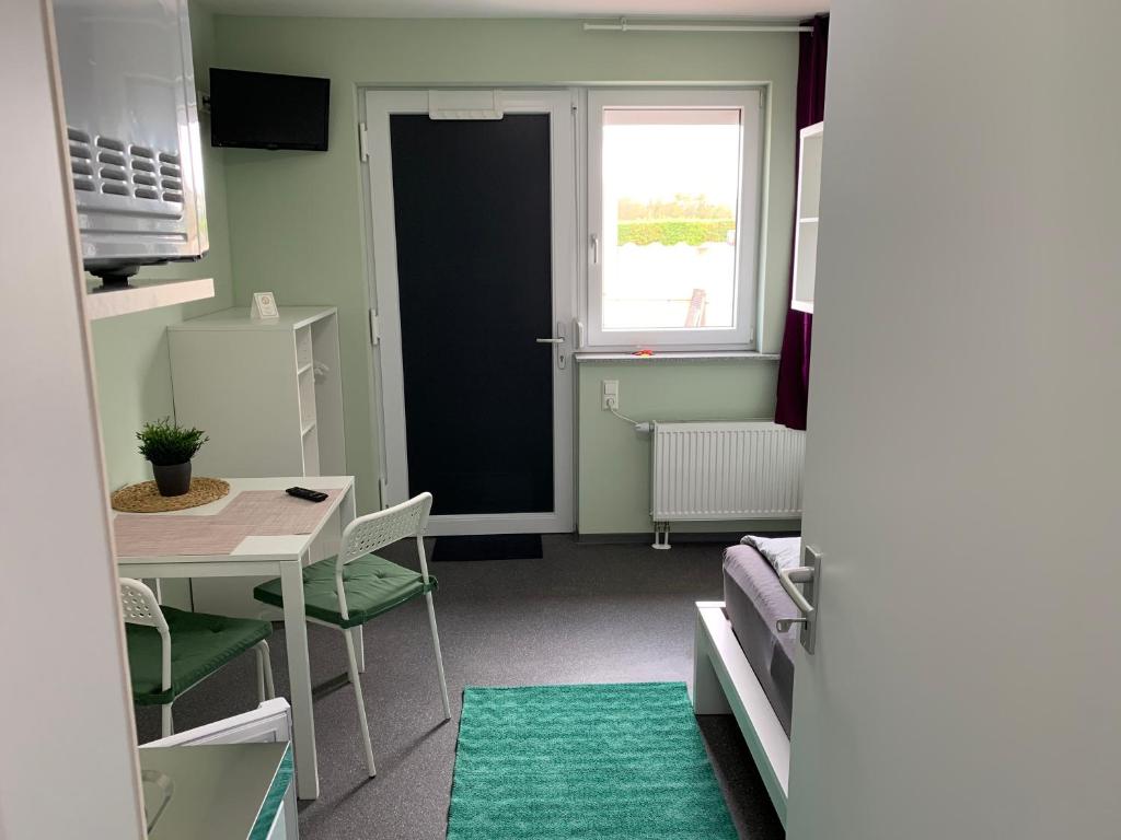 a room with a door and a table and a window at Ullis Pension für Monteure & Handwerker in Malsch