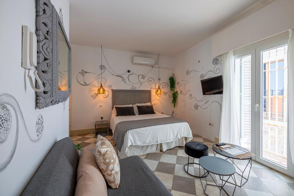 a bedroom with a bed and a couch in a room at La Casa de la Favorita in Tarifa