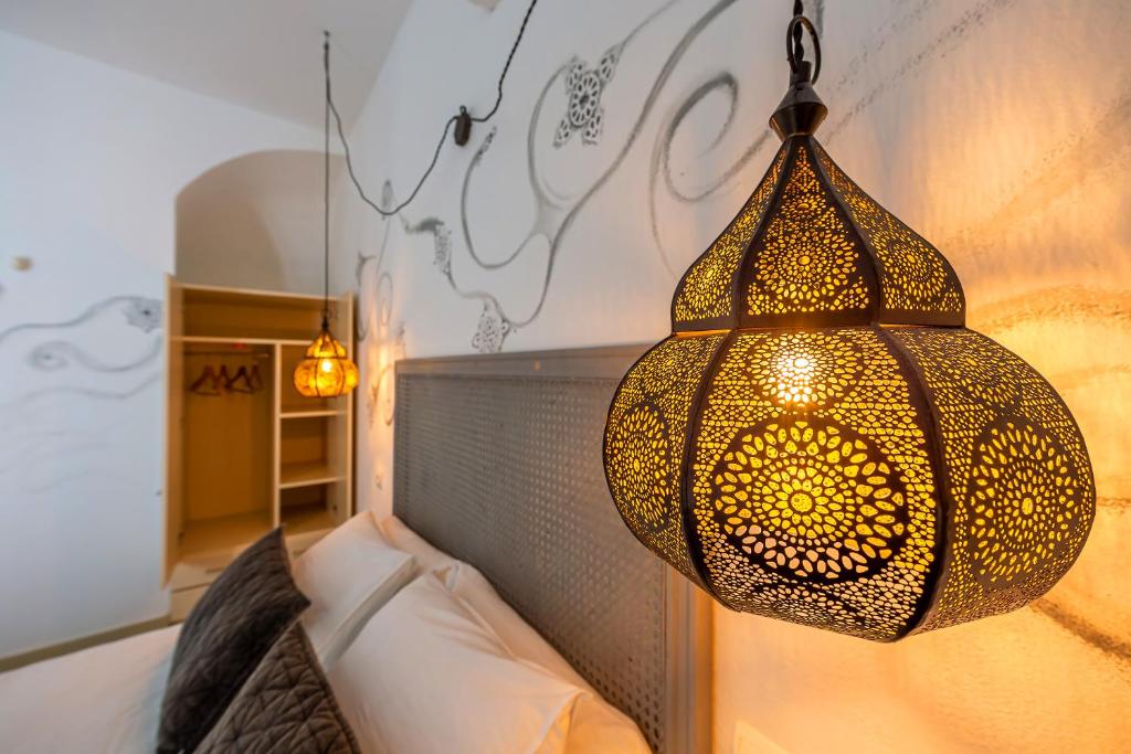a chandelier hanging over a bed in a bedroom at La Casa de la Favorita in Tarifa