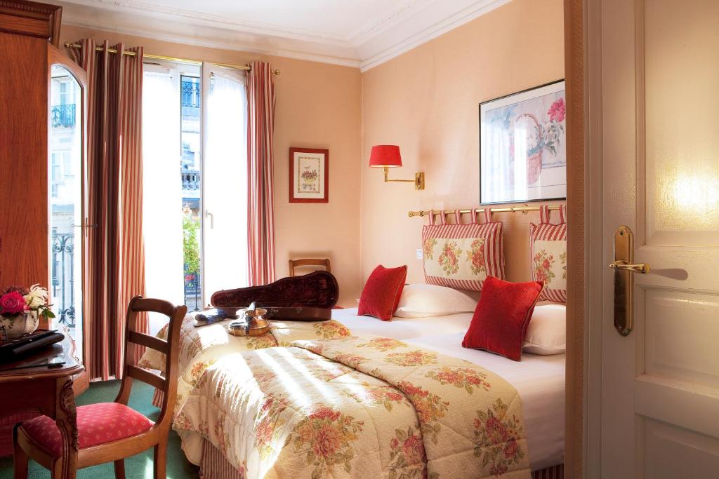 a hotel room with a bed and a window at New Orient Hotel in Paris