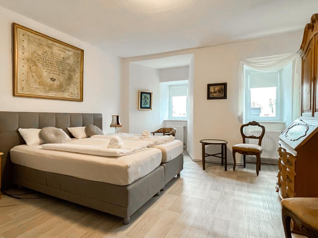 ein Schlafzimmer mit einem großen Bett und einem Stuhl in der Unterkunft Apartment Fuchsbau in Senftenberg