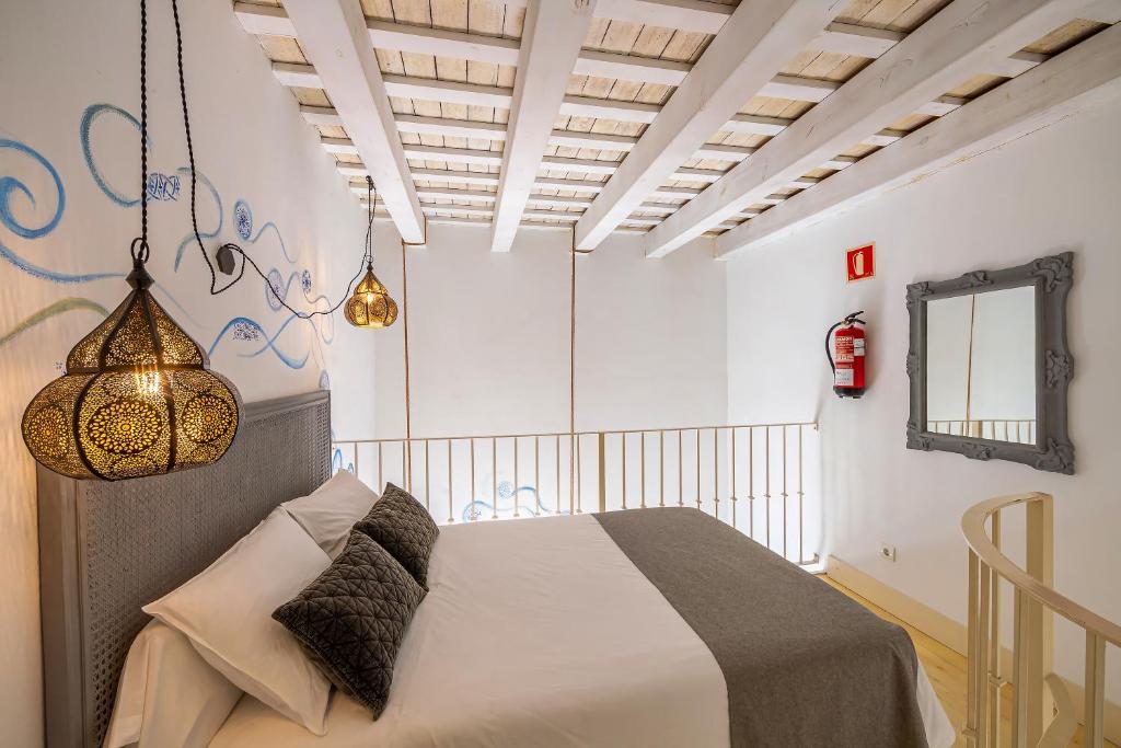 a bedroom with a bed and a chandelier at La Casa de la Favorita in Tarifa