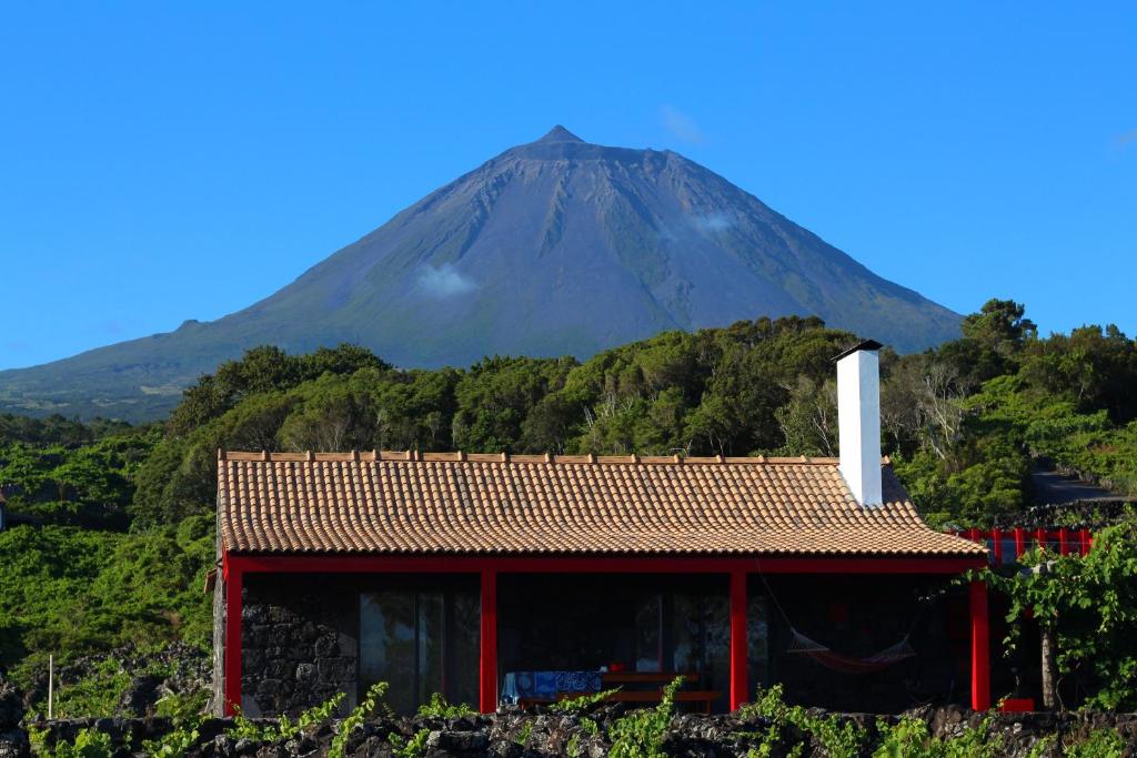 une montagne au loin avec un bâtiment devant dans l'établissement Adega Fraga, à Santa Luzia