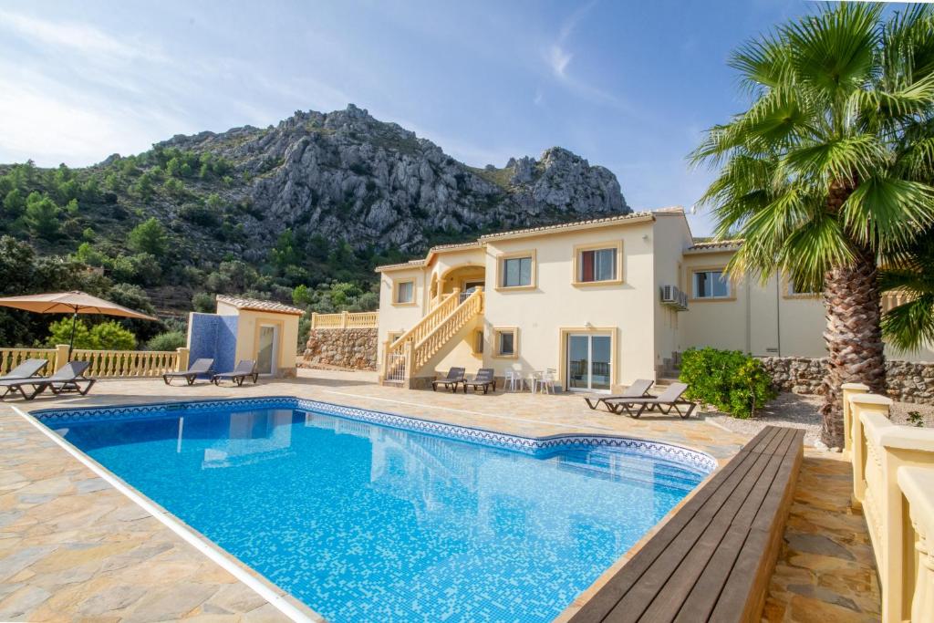 a villa with a swimming pool and a house at Casa Lennisa in La Vall de Laguar