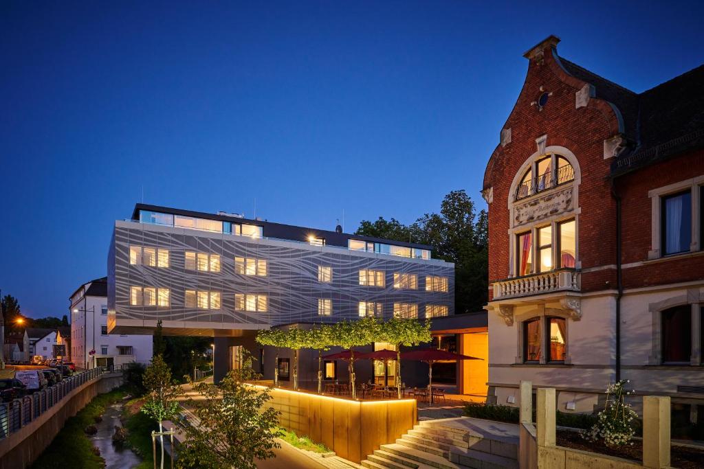 a large building with a glass facade at night at Villa Boutique Hotel in Straubing