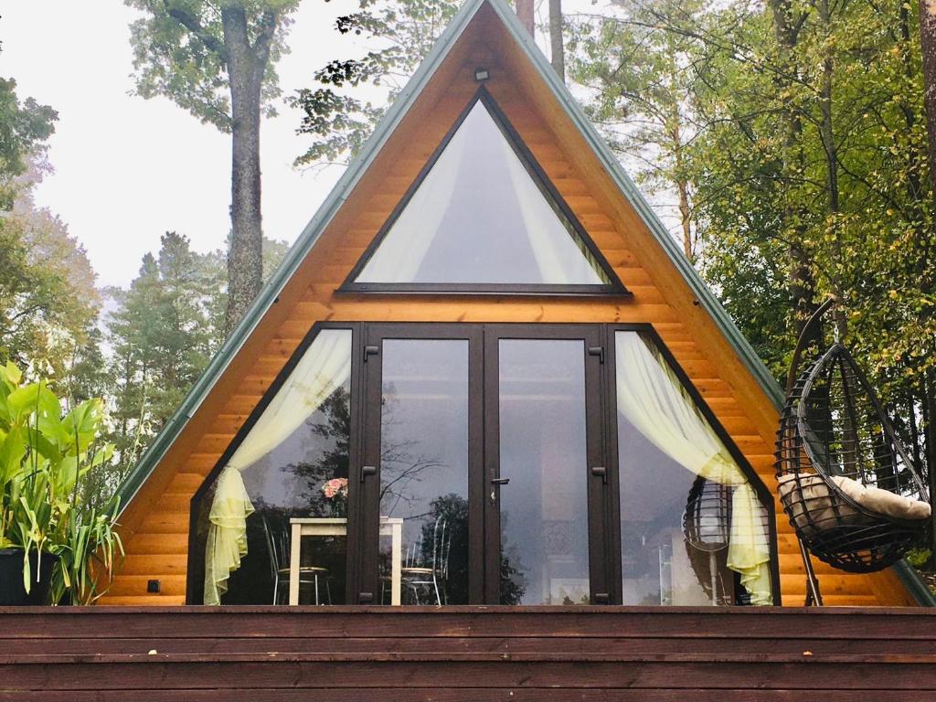 Cabaña de marco con techo triangular y ventanas de cristal en Aleksandra Viesu Namiņš en Aglona