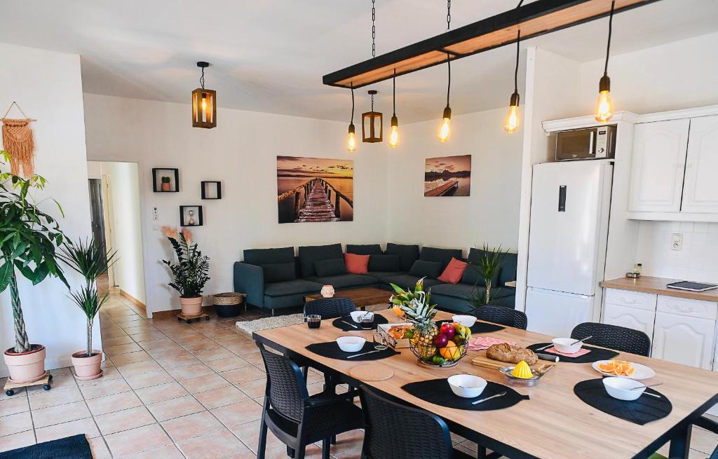 uma cozinha e sala de estar com uma mesa e um sofá em spacieux T5, terrasse, proche centre,parking privé em Perpignan