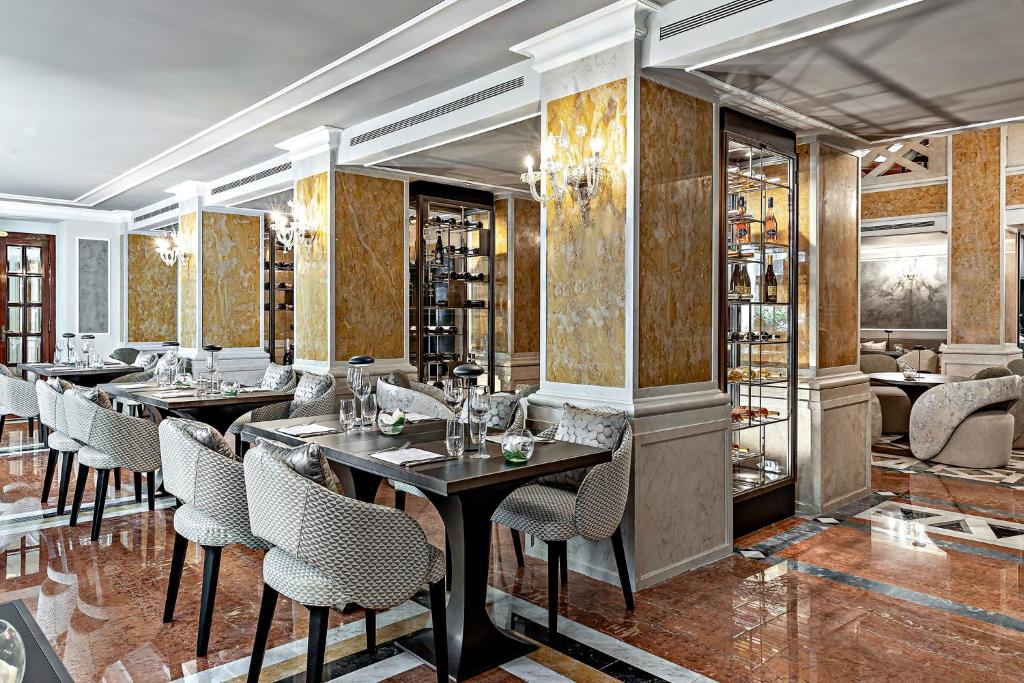 a restaurant with tables and chairs and a bar at Baglioni Hotel Luna - The Leading Hotels of the World in Venice