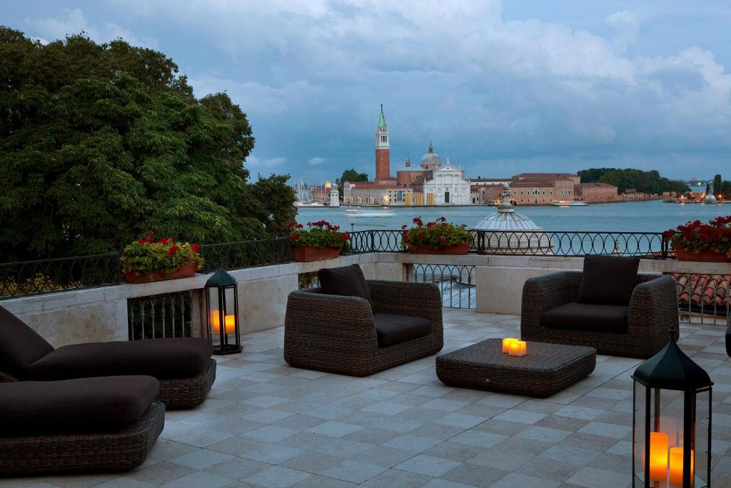 a patio with chairs and a table with a view of the water at Baglioni Hotel Luna - The Leading Hotels of the World in Venice