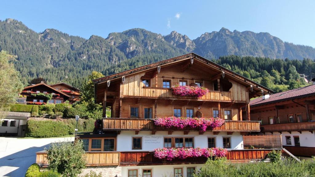a building with flowers on the balconies of it at Wellnessappartements Margit in Alpbach