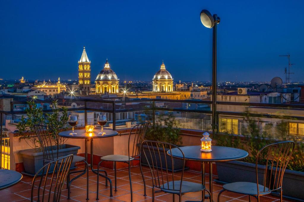 balcone con tavoli, sedie e vista sulla città di Sophie Terrace Hotel a Roma