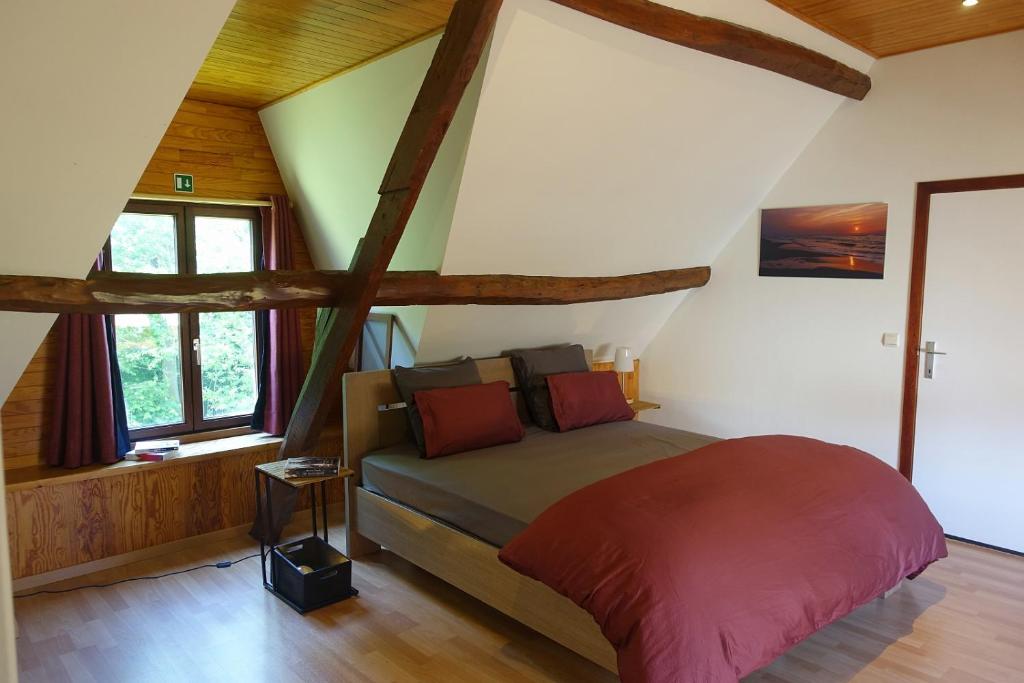 a bedroom with a bed in a room with wooden ceilings at Lien's Cottage in Bruges