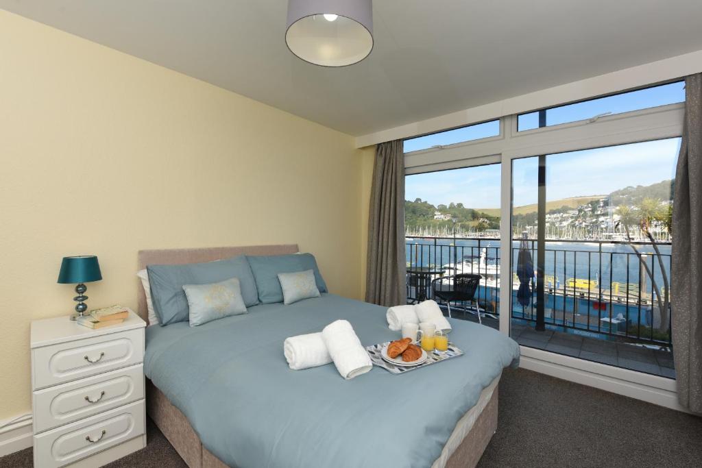 a bedroom with a bed and a large window at Riverside 1 in Dartmouth