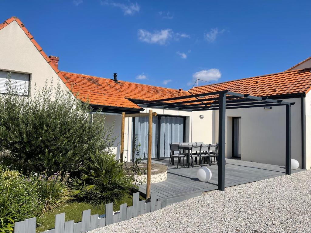 une maison avec une terrasse en bois dans l'arrière-cour dans l'établissement Maison moderne avec jardin à 750m de la mer, à Pornic