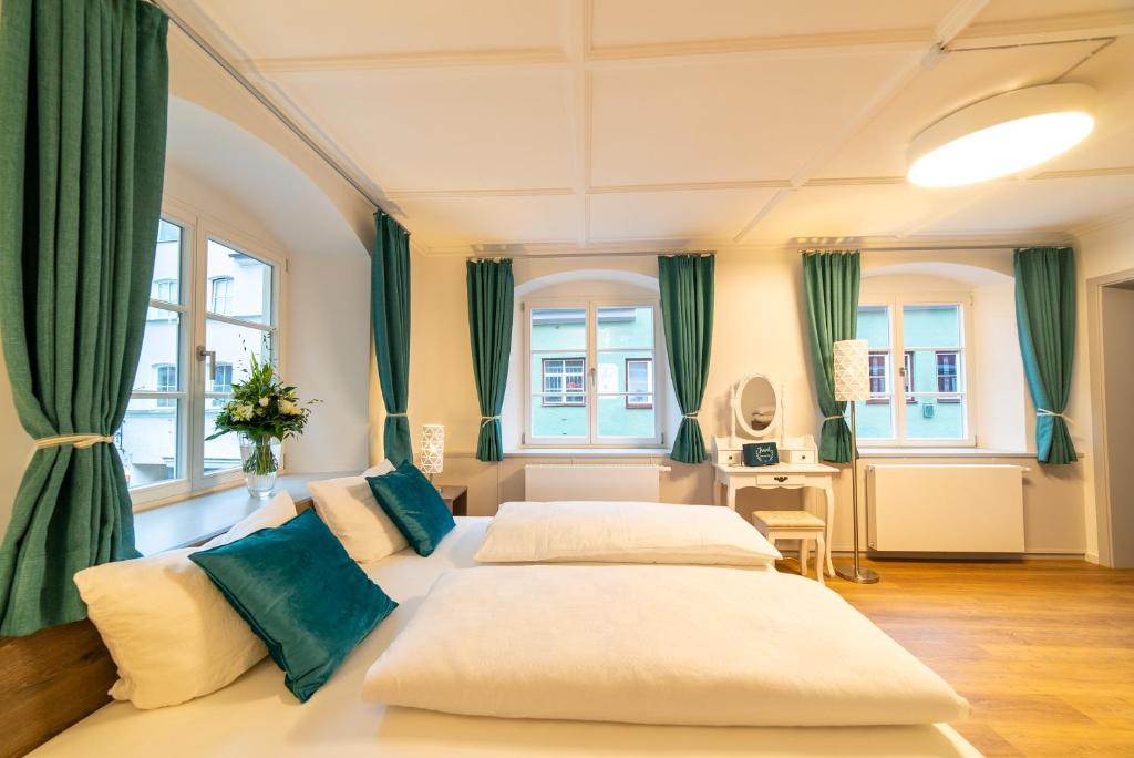 a bedroom with two beds and green curtains at Urban Flair Hotel in Memmingen