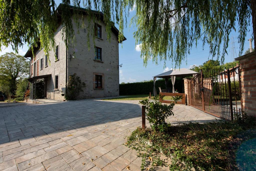 a large stone building with a gazebo in front of it at Agriturismo Cascina Costa in Cassago Brianza