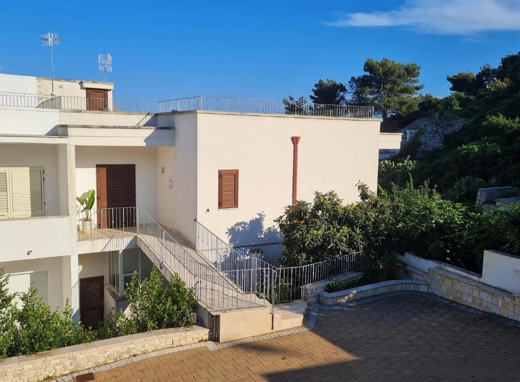 a white building with stairs in front of it at Casa vacanze Vento di mare in Castro di Lecce