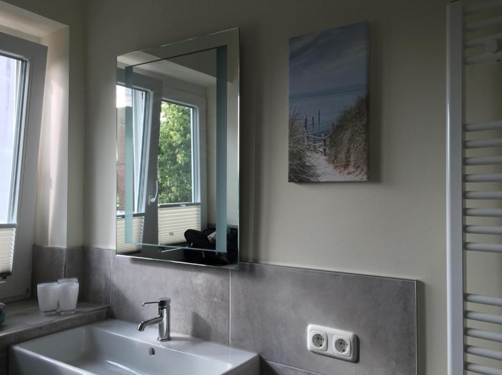 een badkamer met een wastafel en een spiegel bij Ferienwohnung Schauf 2 in Dahme