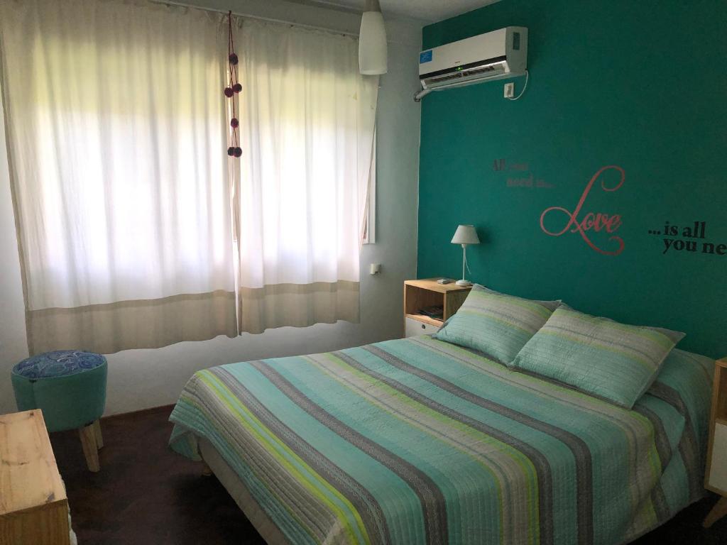 1 dormitorio con cama y pared verde en Cozy, Bright, near everything./Cómodo, luminoso, cerca de todo. en Rosario
