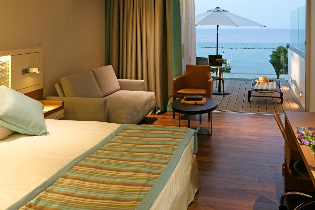 a hotel room with a bed and a living room at Crowne Plaza Limassol by IHG in Limassol