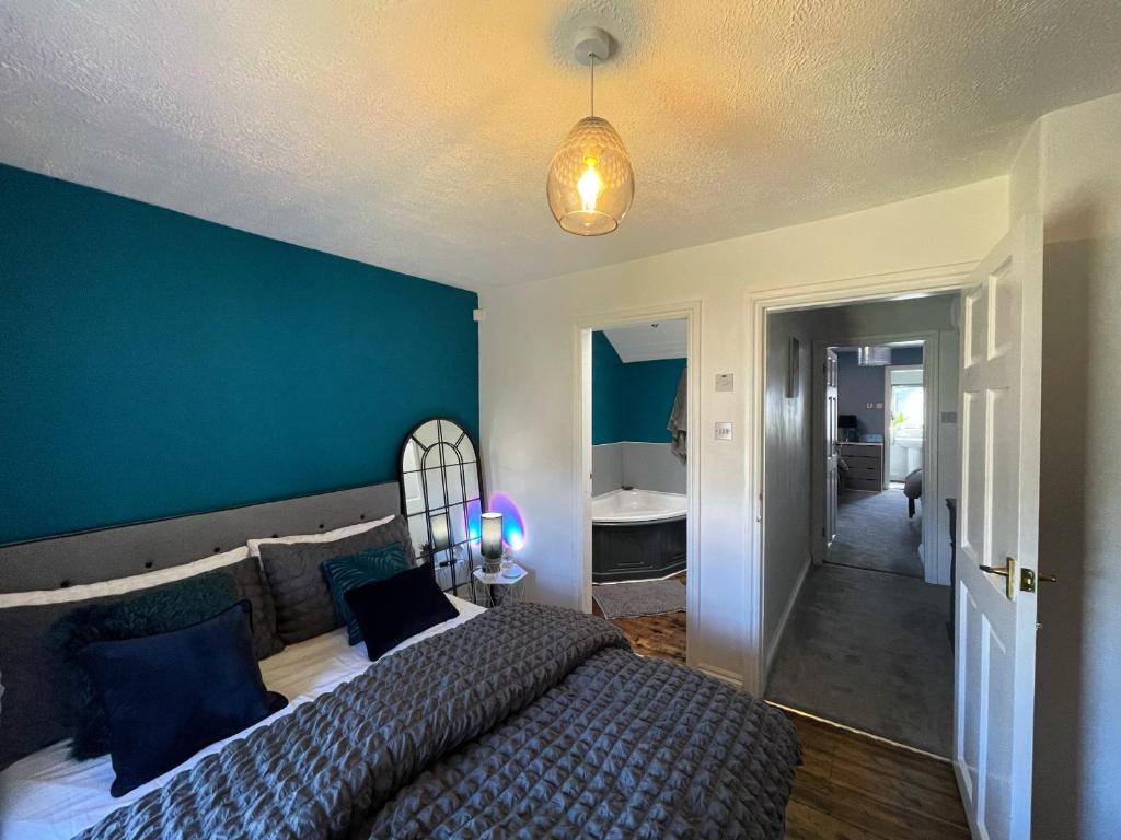 1 dormitorio con 1 cama grande y pared azul en Mynydd A Môr, en Trevor