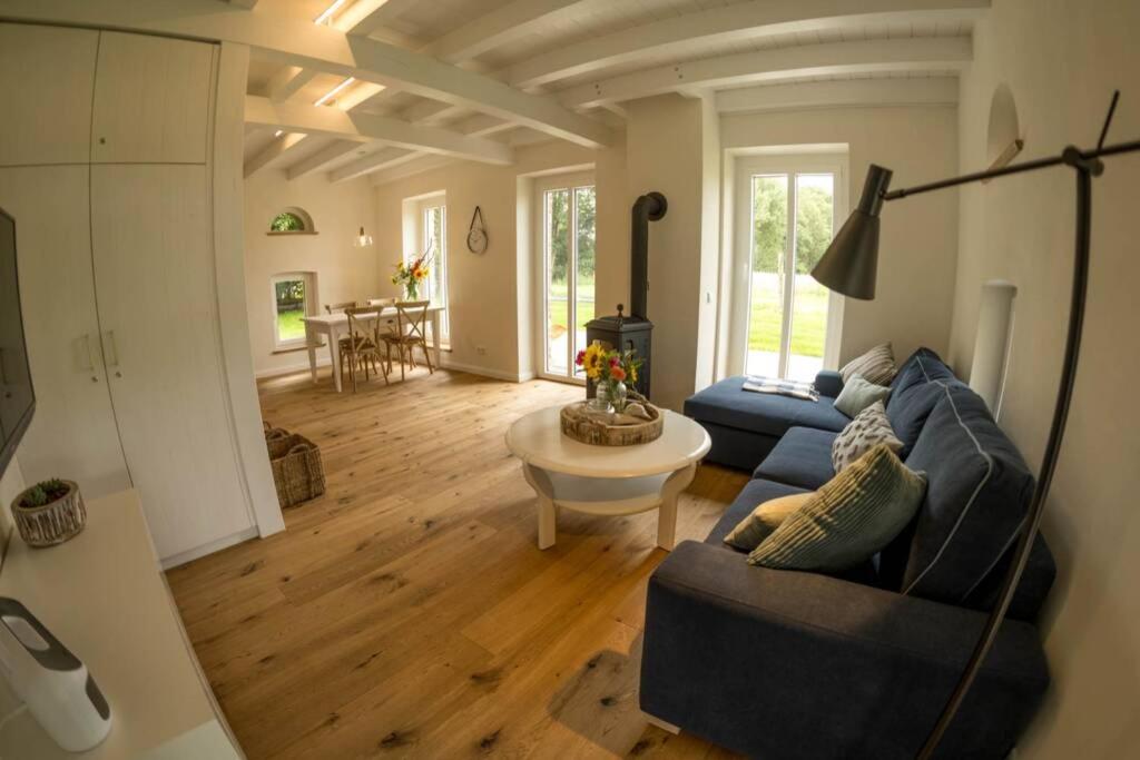 una sala de estar con 2 sofás azules y una mesa. en Zum Heuerling Ferienwohung im alten Stall mit Sauna en Versmold