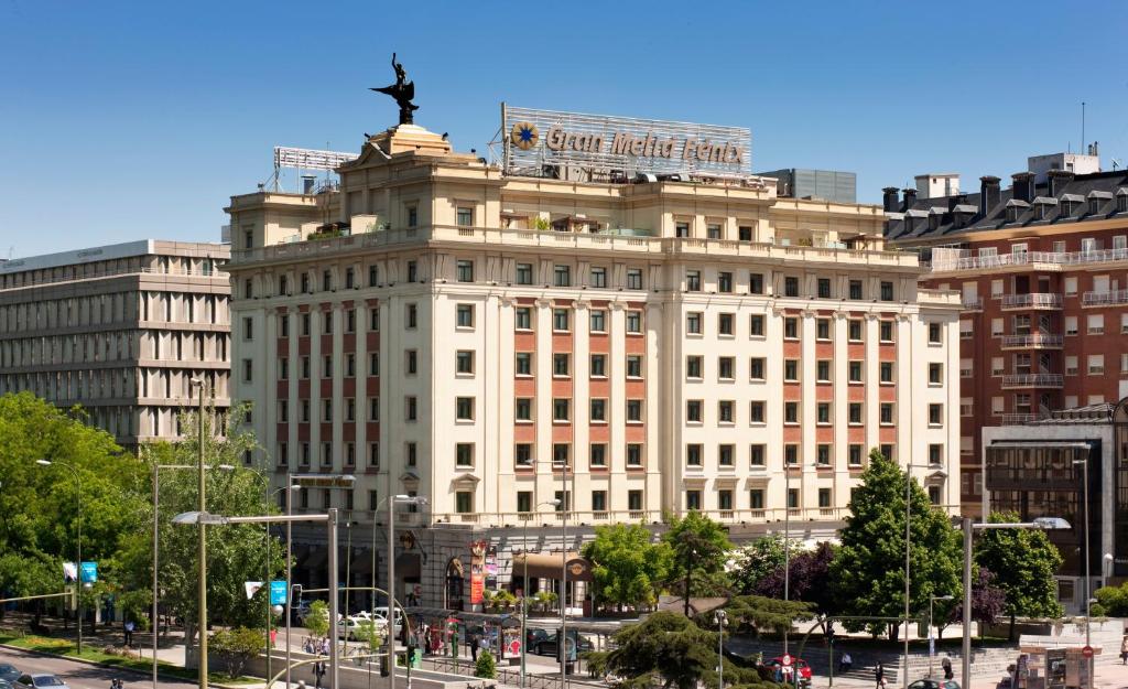 a large white building with a statue on top of it at Hotel Fenix Gran Meliá - The Leading Hotels of the World in Madrid