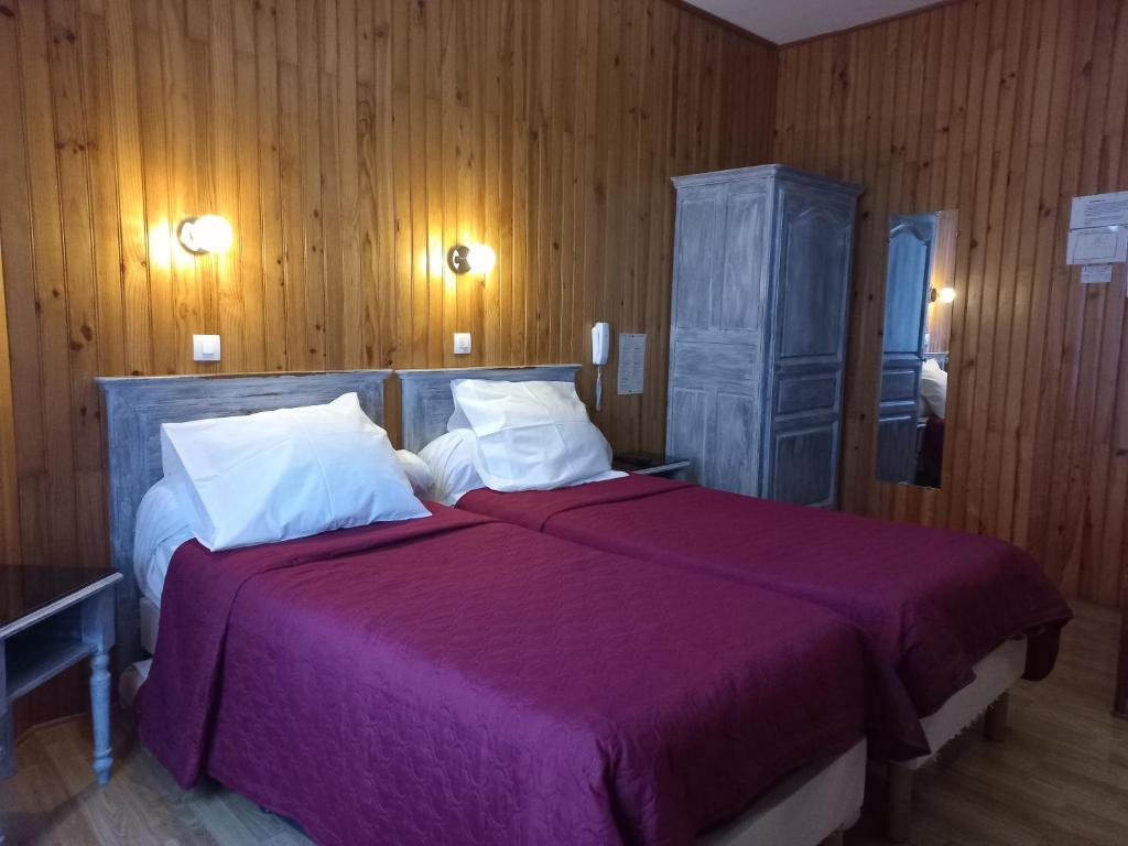 - une chambre avec 2 lits dotés de draps violets et de murs en bois dans l'établissement Hôtel Paris Nord, à Paris