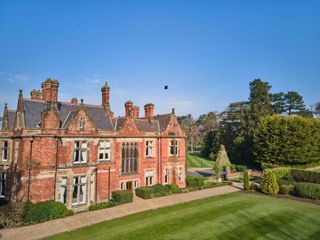an old red brick mansion with a yard at Rockliffe Hall Hotel Golf & Spa in Darlington