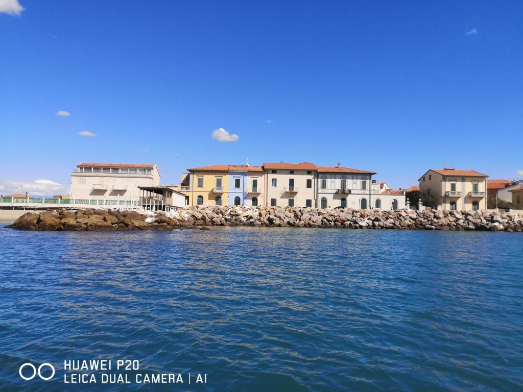 grupa domów na brzegu wody w obiekcie bilocale Marina di Pisa w mieście Marina di Pisa