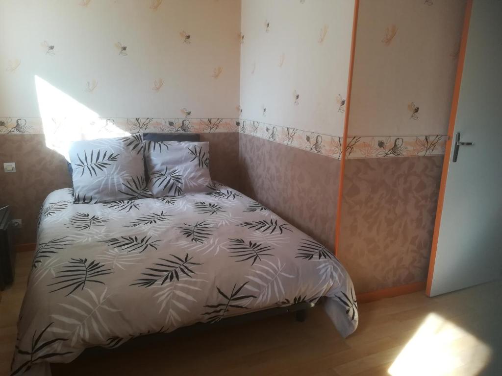 een slaapkamer met een bed met een zwart-wit dekbed bij Chambre double avec WiFi châtellerault in Châtellerault