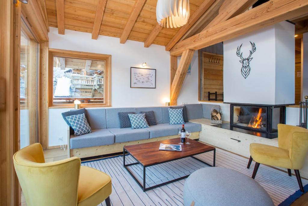 un salon avec un canapé bleu et une cheminée dans l'établissement Simply Morzine - Chalet Zormine, à Morzine