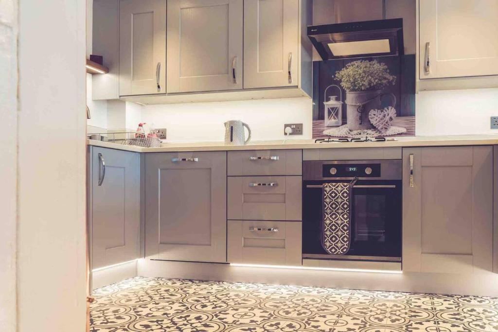 a kitchen with gray cabinets and a stove top oven at 3-Bed Cottage-Plymouth-Dog friendly-Sleeps7 in Plymouth