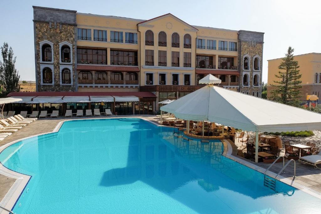 a large swimming pool in front of a building at Caucasus Hotel in Yerevan